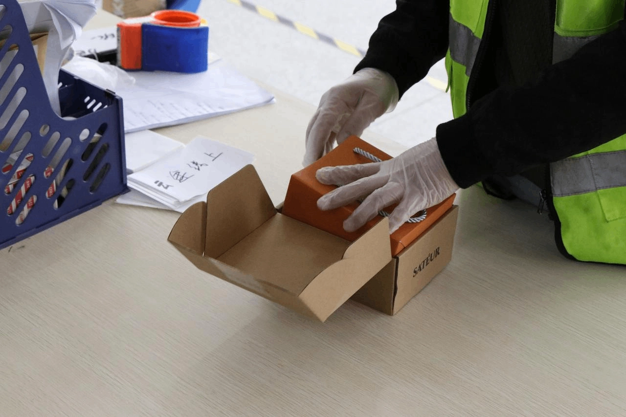 SFC staff preparing custom packaging at a packing workstation